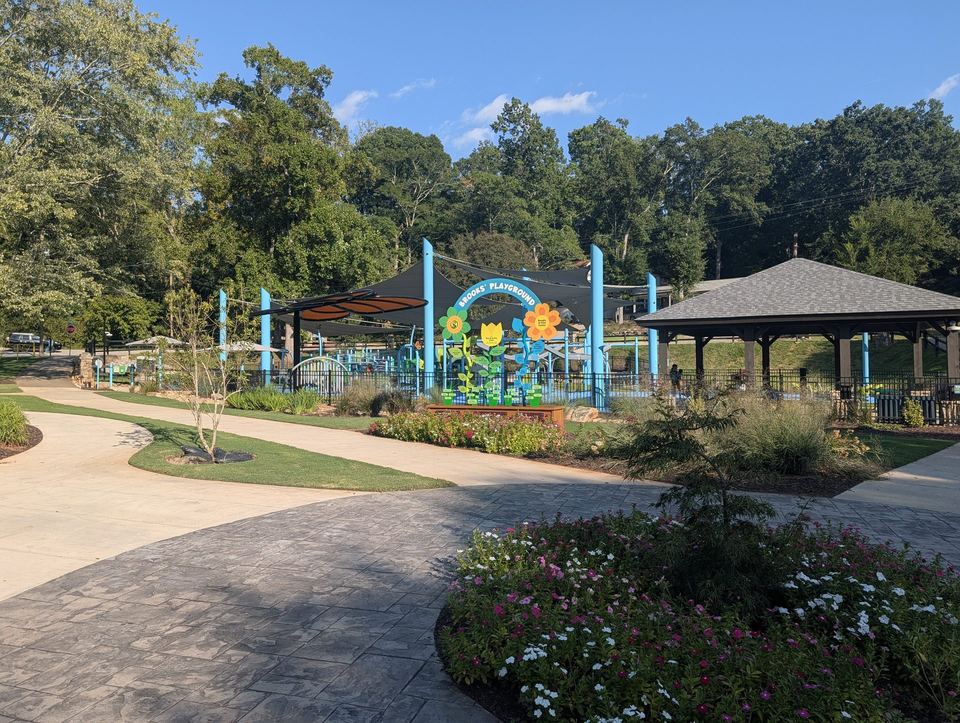 A new playground with play structures on open ground in Cleveland Park.